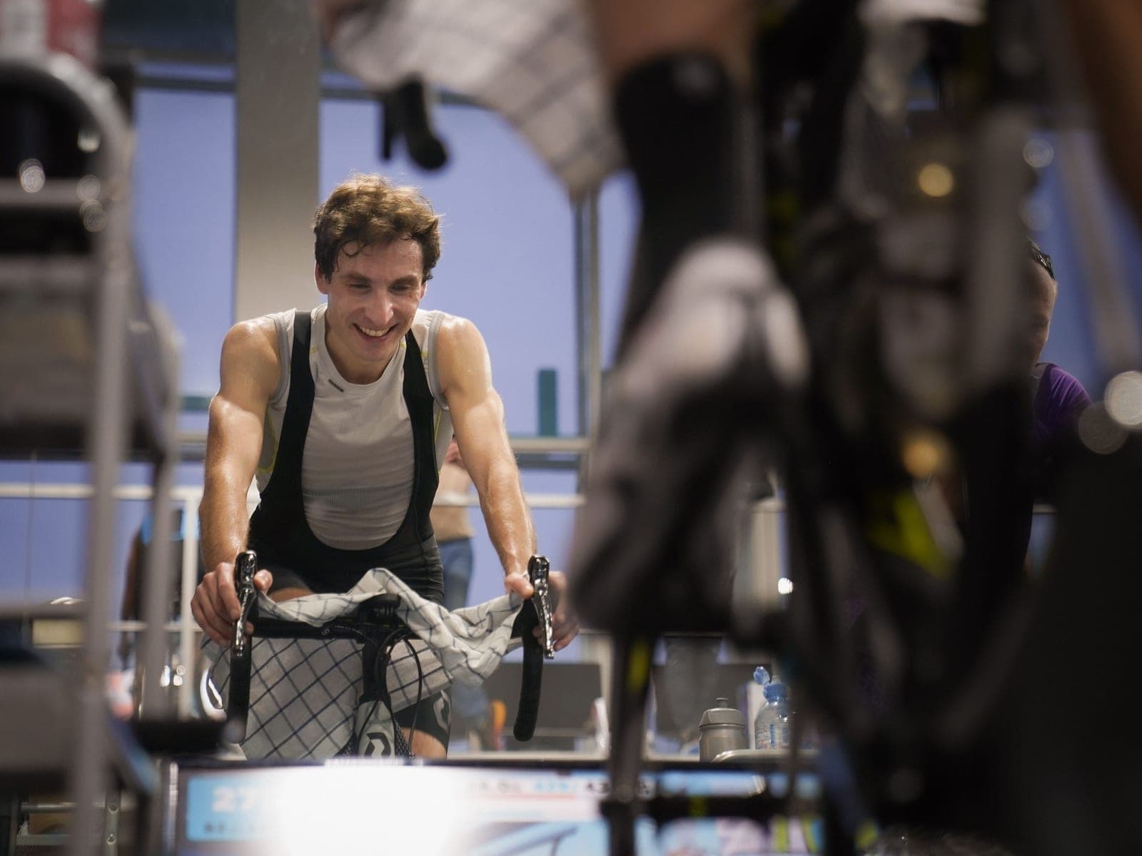 A cyclist training hard on an indoor bike trainer in a home pain cave